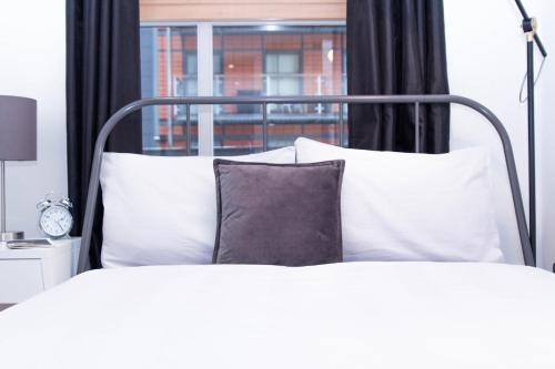 マンチェスターにあるDouble bed + private bathroom in Manchester City Centre.のベッドルーム1室(白い枕のベッド1台、窓付)