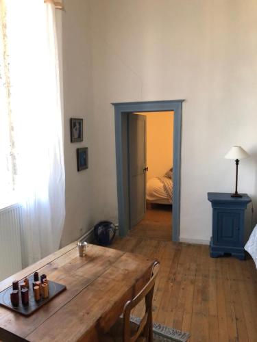 a living room with a wooden table and a bedroom at L'Ancien Couvent Cahuzac in Cahuzac