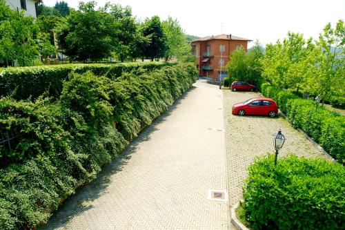 a red car parked on a sidewalk next to a hedge at Albergo Sapori in Tolè