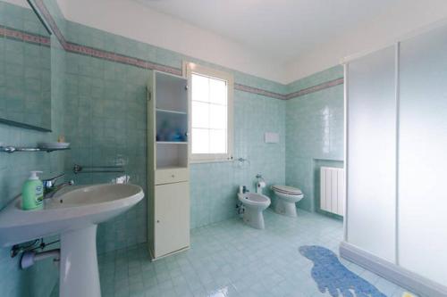 ein Badezimmer mit Waschbecken und Toilette und einem Fenster in der Unterkunft Appartamento Arzachena Costa Smeralda in Arzachena