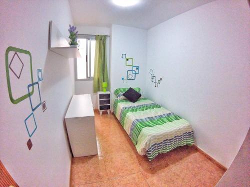 a small bedroom with a bed and a window at Piso 8 Personas Wifi 500Mb in Telde