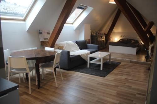 ゲブヴィレールにあるAppartement et gîte Chez l'Habitantのリビングルーム(テーブル、ソファ付)
