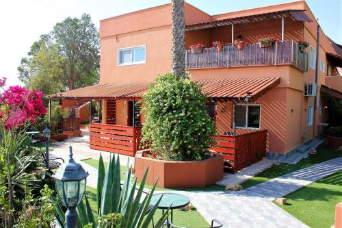 a house with a balcony with plants and a table at Dead Sea Sun Guest House in Arad