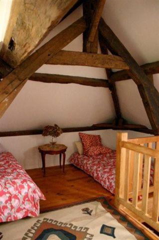 une chambre mansardée avec deux lits et une table dans l'établissement La Palestriere, à Cuy-Saint-Fiacre