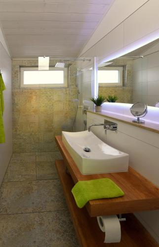 a bathroom with a white sink and a green towel at PETIT-CHALET AM HAINER SEE in Rötha