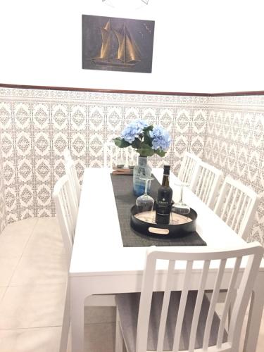 a white dining room table with white chairs at Starfish House in Vila Nova de Gaia