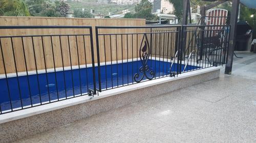 a black fence with a swimming pool behind it at Lake Mansion in Tiberias