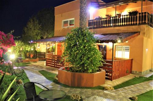 a house with a tree in front of it at night at Dead Sea Sun Guest House in Arad