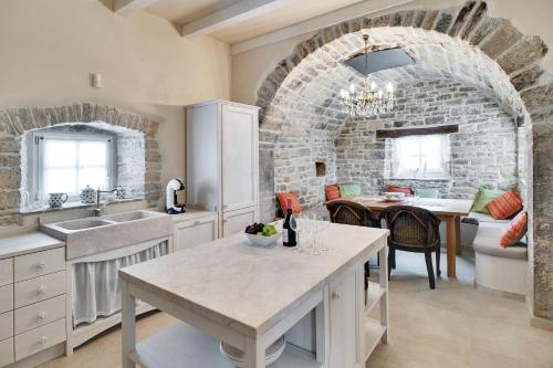 a kitchen with a table and a brick wall at Casa Meloni in Motovun