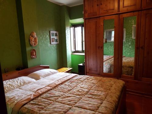 a bedroom with a bed and green walls at Le Dimore di Angelo in SantʼEufemia a Maiella