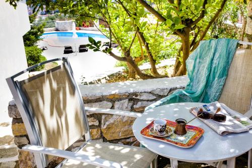 einen Tisch und einen Stuhl mit einem Tablett mit Essen und einer Tasse Kaffee in der Unterkunft Blue Horizon Studios in Skiathos-Stadt