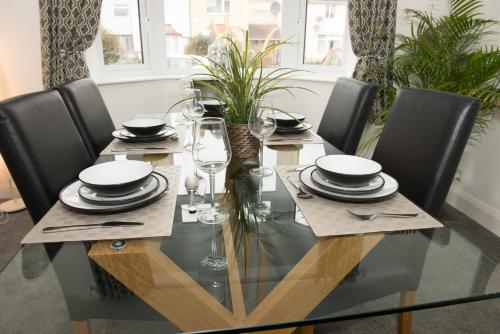 a dining room table with black chairs and a glass tableablish at Arma Short Stays 122 - Spacious 3 Bed Oxford House Sleeps 6- FREE PARKNG For 2 Vehicles - Large Garden in Oxford