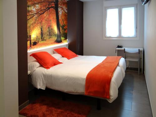 a bedroom with a bed with orange pillows and a window at Bekale in Ea
