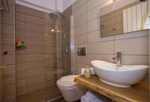 a bathroom with a sink and a toilet and a shower at The Five Keys Apartments in Limenaria