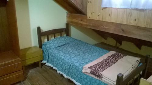 Dormitorio pequeño con cama con cabecero de madera en Dúplex en San Clemente a 1 cuadra de la playa y 2 del centro en San Clemente del Tuyú