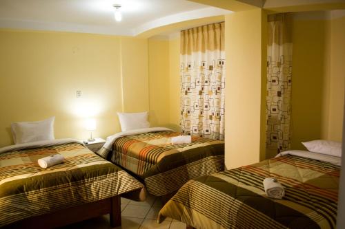 a hotel room with two beds in a room at Hotel Residencial Tamia in Huaraz