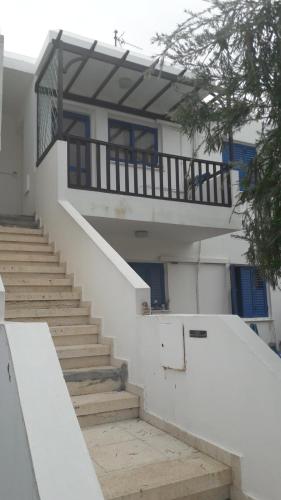 a staircase leading to a building with a balcony at Rita SeaView Apartment in Pervolia