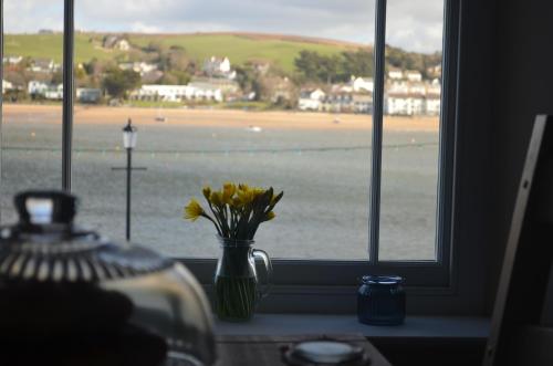 a vase with yellow flowers sitting on a window sill at Appledore Factory in Appledore