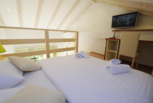 a bedroom with two white beds and a television at Apartman Murter Chill Spot A2+1 ID 722 in Murter