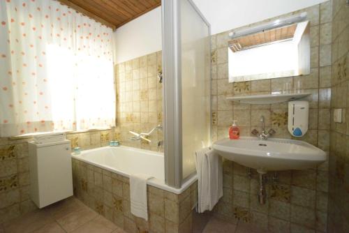 a bathroom with a sink and a bath tub at Ferienhaus Anger in Bad Hofgastein