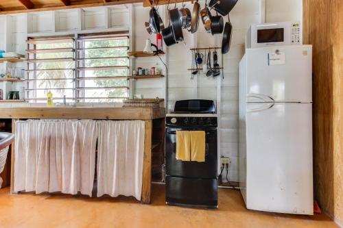 a kitchen with a stove and a refrigerator at Amanda's Place Casa Amancer - sea view, pool and tropical garden in Caye Caulker
