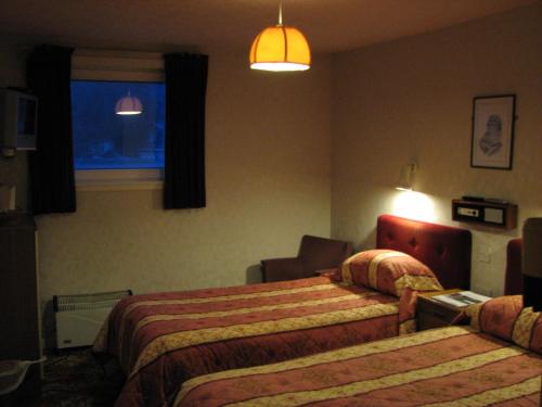 a hotel room with two beds and a window at Lancaster Hotel in Oban