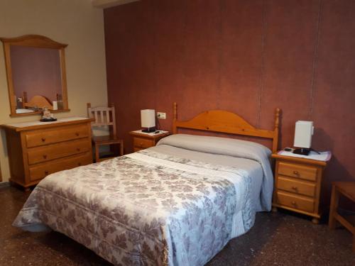 una camera da letto con un letto, due cassettiere e uno specchio di Apartamento Sallan Ainsa Ordesa Zona Zero ad Aínsa