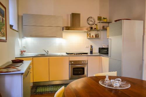 a kitchen with a table and a white refrigerator at Dimora Montebello in Pitigliano