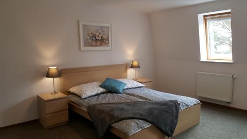 a bedroom with a bed with two night stands and two lamps at Apartament rodzinny z ogrodem - Bliżej Zdroju in Polanica-Zdrój