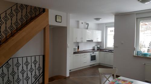 a kitchen with white cabinets and a staircase at Apartament rodzinny z ogrodem - Bliżej Zdroju in Polanica-Zdrój