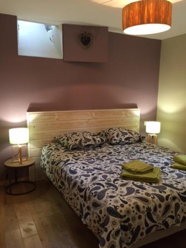 a bedroom with a bed with two lamps on it at Le Nessmann in Sarlat-la-Canéda