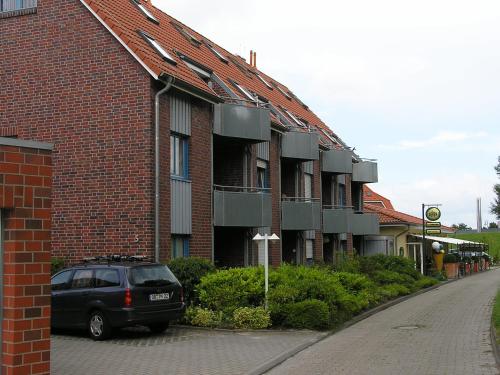 a car parked in front of a brick building at Strandkorb in Horumersiel