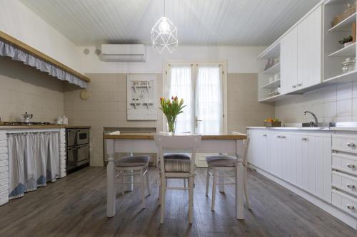 a kitchen with white cabinets and a table with stools at B&B Arco Di Pietra in Quinto di Treviso