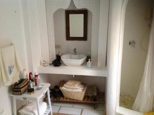 un baño con lavabo y espejo en Casa Vacanza Porto Luna 68, en Villasimius