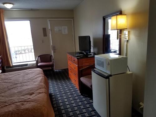 a hotel room with a bed and a refrigerator with a microwave at Americas Best Value Inn - Augusta / South in Augusta