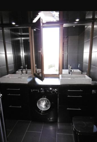 une salle de bain avec deux lavabos et une fenêtre dans l'établissement Black loft, au Cap d'Agde