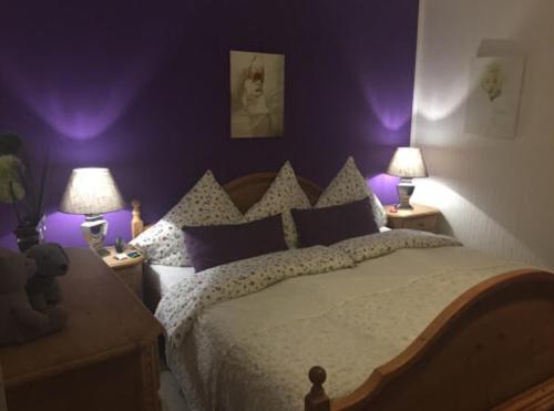 a purple bedroom with a bed and two lamps at Ferienwohnung Villa Wohntraum in Varel