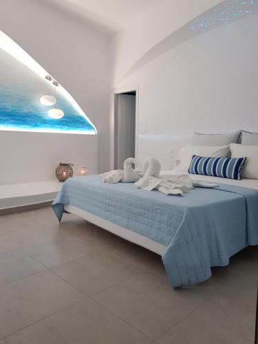 a bedroom with a bed with two stuffed animals on it at Amera Suites in Fira