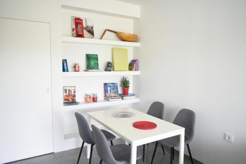 a white table and chairs in a room with shelves at Verde Apartments in Athens