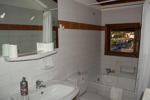 a bathroom with a sink and a toilet and a window at Staggia Studios in Sami