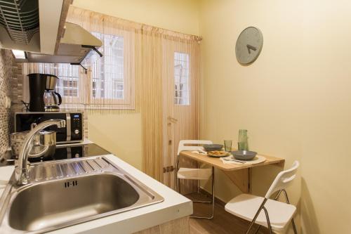 アテネにあるPrivate Central View rooms in apartment near to Acropolis Metro Stationのキッチン(シンク、テーブル、椅子付)