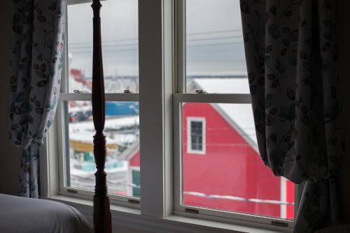 a bedroom window with a view of a red barn at Salt Shaker Deli & Inn in Lunenburg