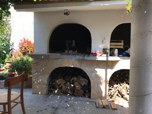 a stone fireplace in a patio with a table at Apartmani Sali Seaview in Sali
