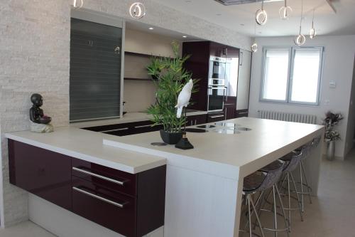 une cuisine avec un grand îlot et un comptoir blanc dans l'établissement Appartement 3 pièces Nice Promenade des anglais dernier étage vue mer solarium, à Nice