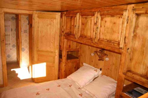 ブリアンソンにあるL'ancolieのベッドルーム1室(ベッド1台、木製の壁、キャビネット付)