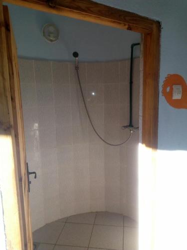 a bathroom with a shower with a hose on the wall at Auberge Amazigh in Tamtetoucht
