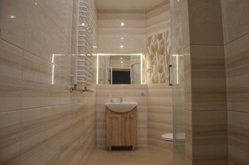 a bathroom with a sink and a mirror at Ada Aparthouse in Wrocław