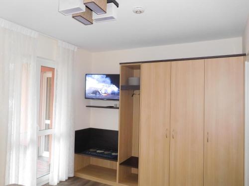 a living room with a tv and a wooden cabinet at Ferienwohnung Kurpark in Xanten