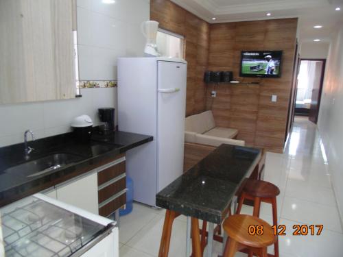 a kitchen with a refrigerator and a table and chairs at Propriedade Silva in Gamboa