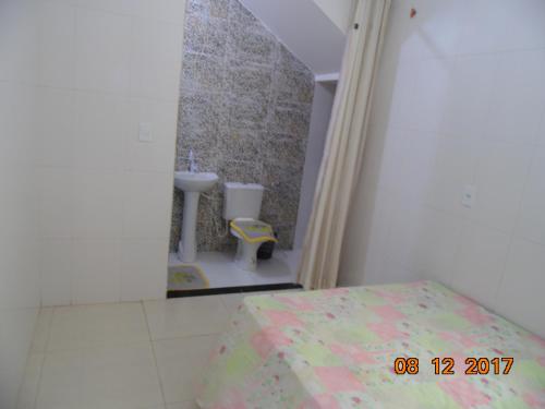 a bathroom with a sink and a bed in a room at Propriedade Silva in Gamboa